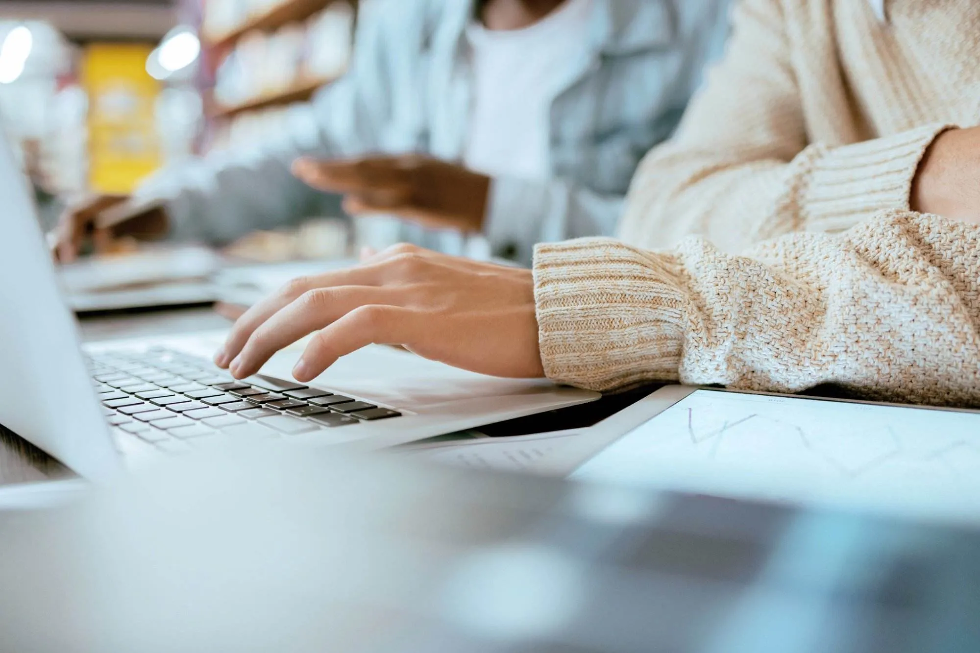 Person typing on laptop deciding between Wordpress and Squarespace