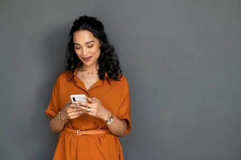 Young professional creating a social media content calendar on her phone.